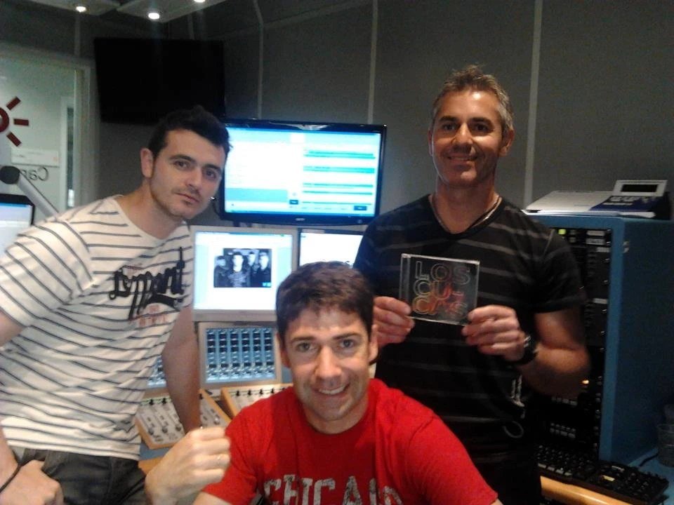 Tres miembros de Los Cucas en un estudio de radio, enseñando su CD